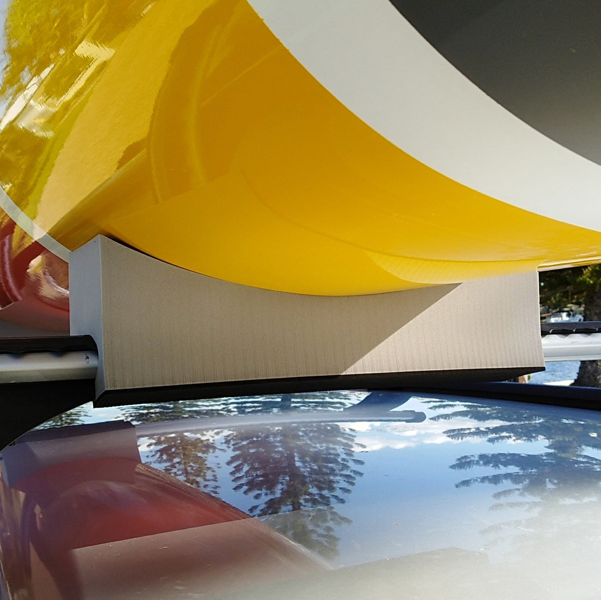 close up of  kayak supported by foam kayak mounts on car roof rack
